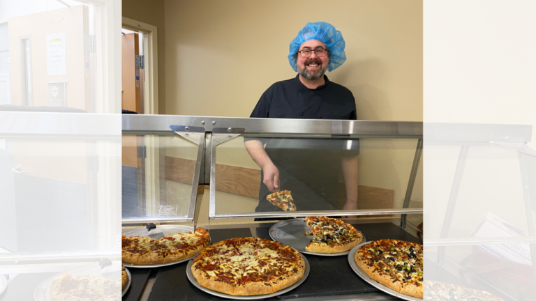 Svenn from dietary service serving pizza in the cafe at CCMH